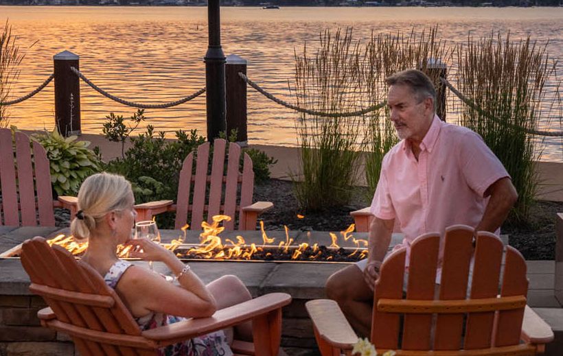 A couple enjoys time by the fire pits and watches a beautiful sunset at the Chautauqua Harbor Hotel