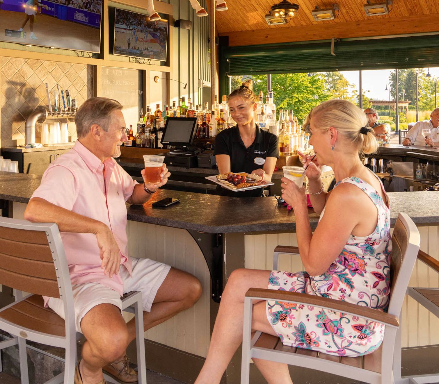 Two adults sipping drinks at the Carousel Bar at Chautauqua Harbor Hotel in Chautauqua Lake