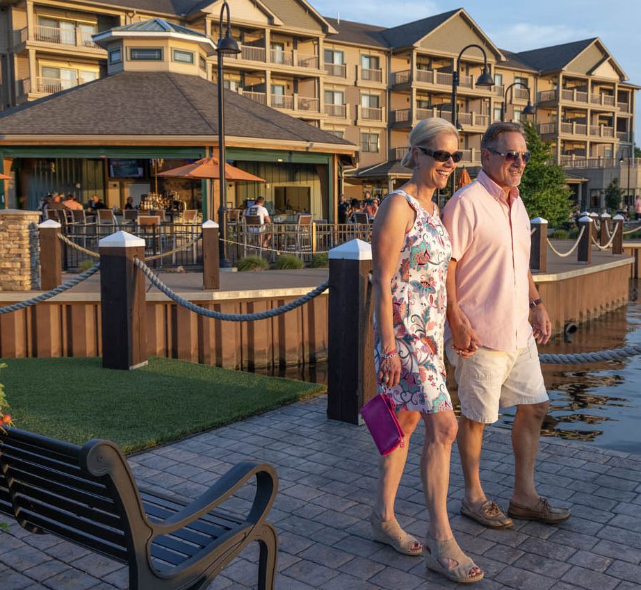 A couple walking on the bridge between the Carousel Bar and the island