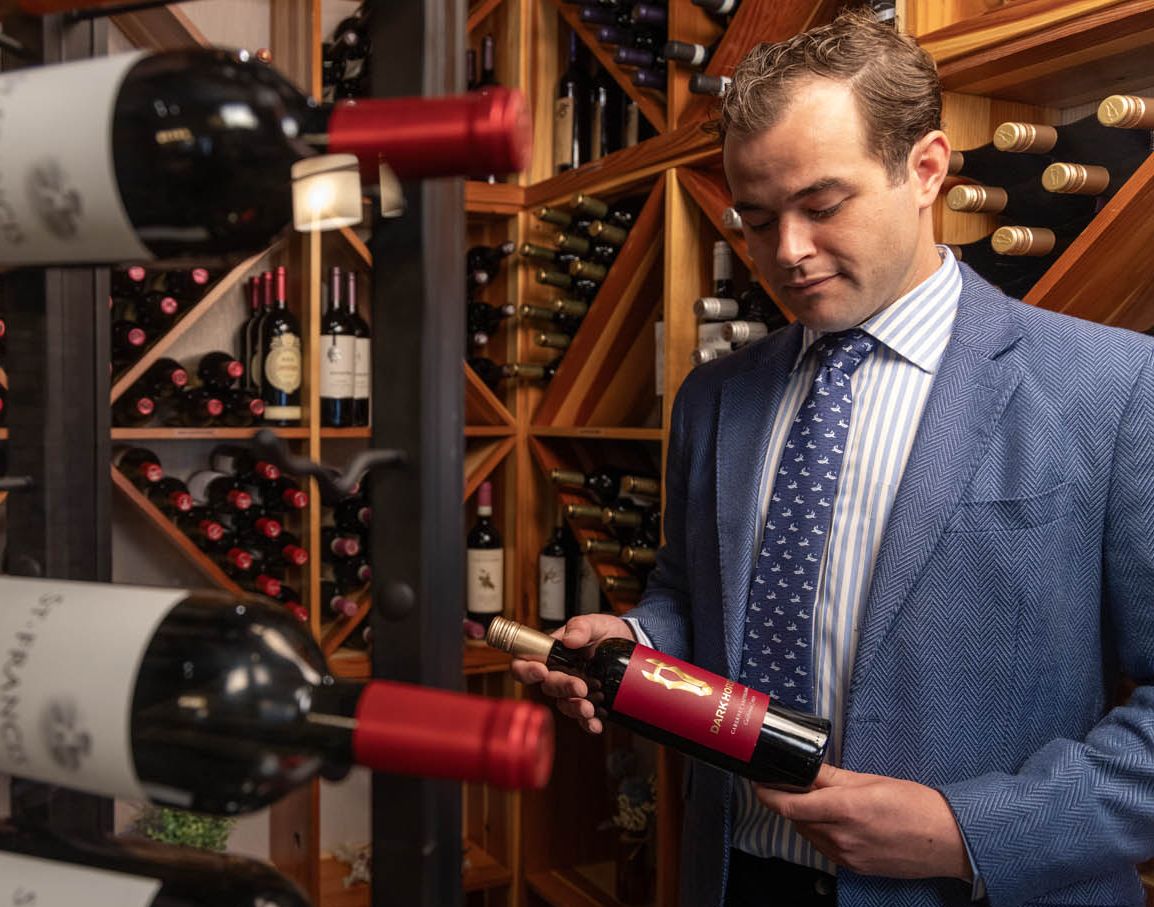 A sommelier examines a bottle of wine from our wine vault at Chautauqua Harbor Hotel