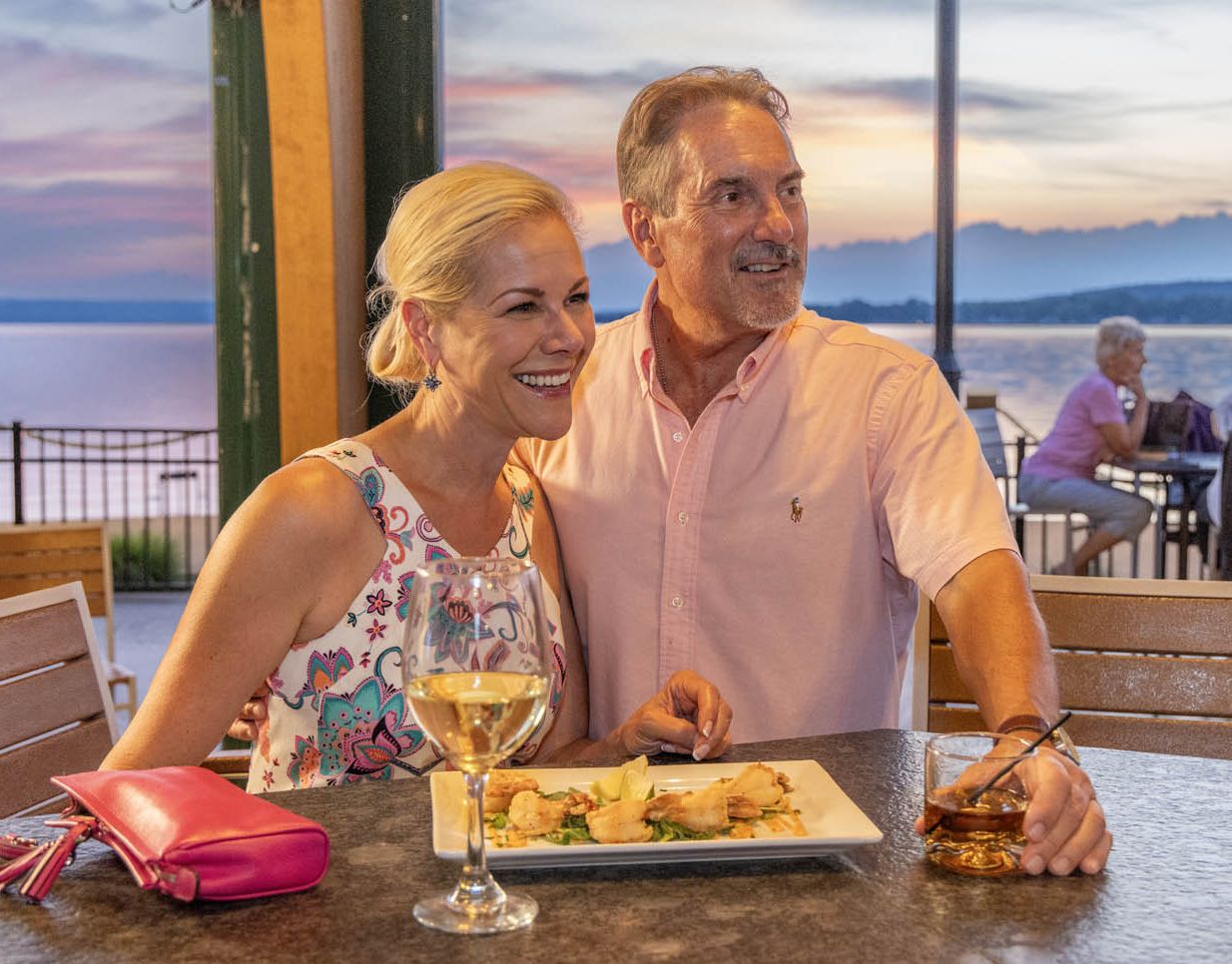 A couple enjoys some beverages and a shrimp appetizer at the Carousel Bar at Chautauqua Harbor Hotel on Chautauqua Lake